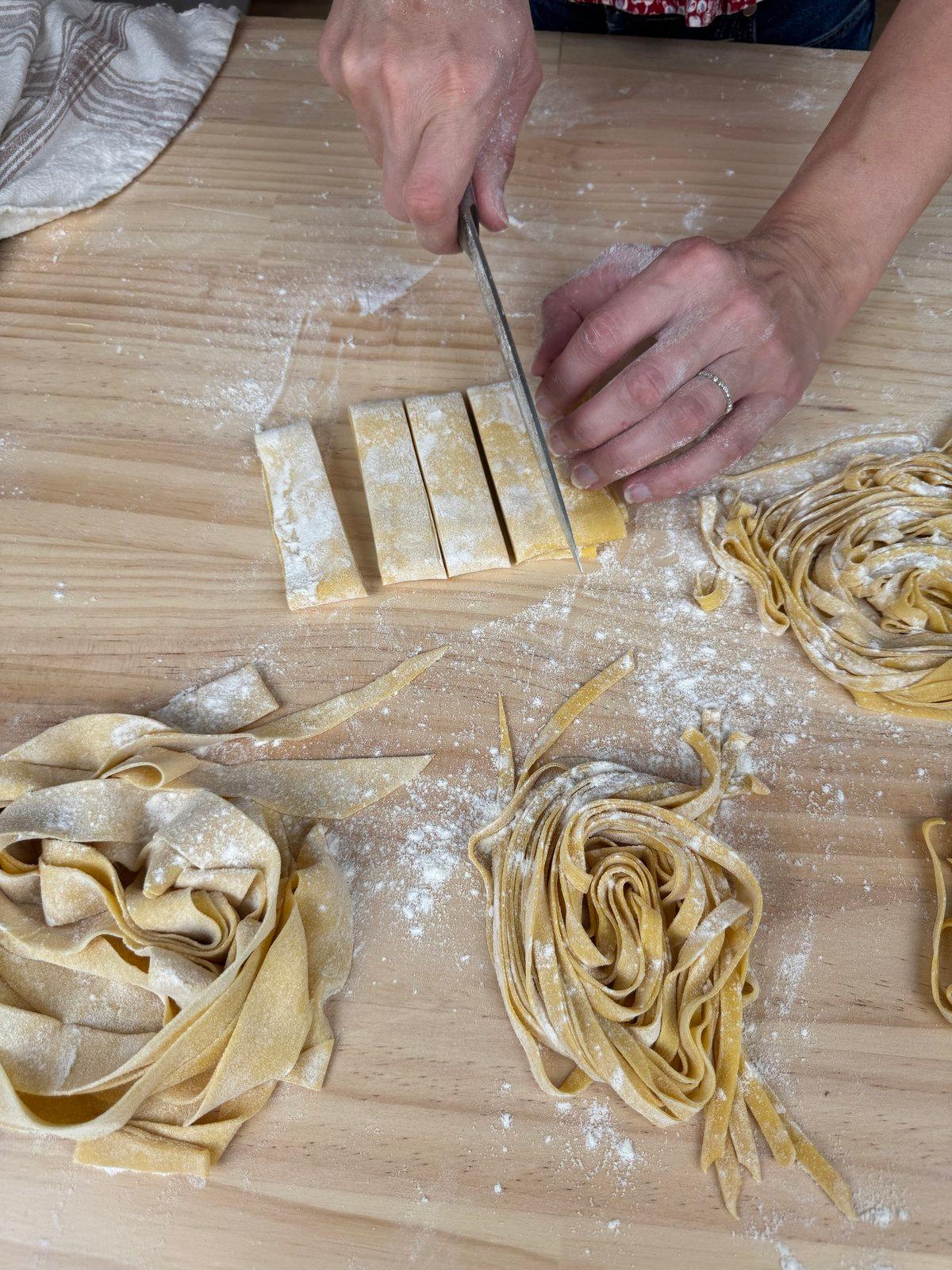 Cutting fresh pasta by hand on a floured board