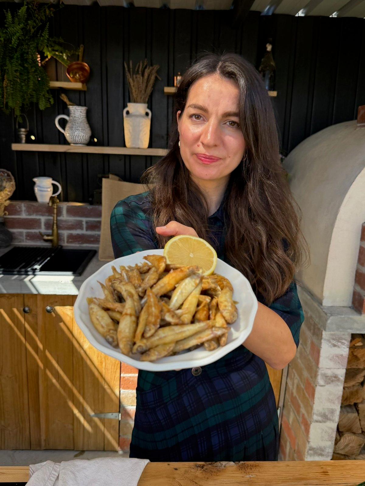 Snezana holding a plate of fried girice with lemon