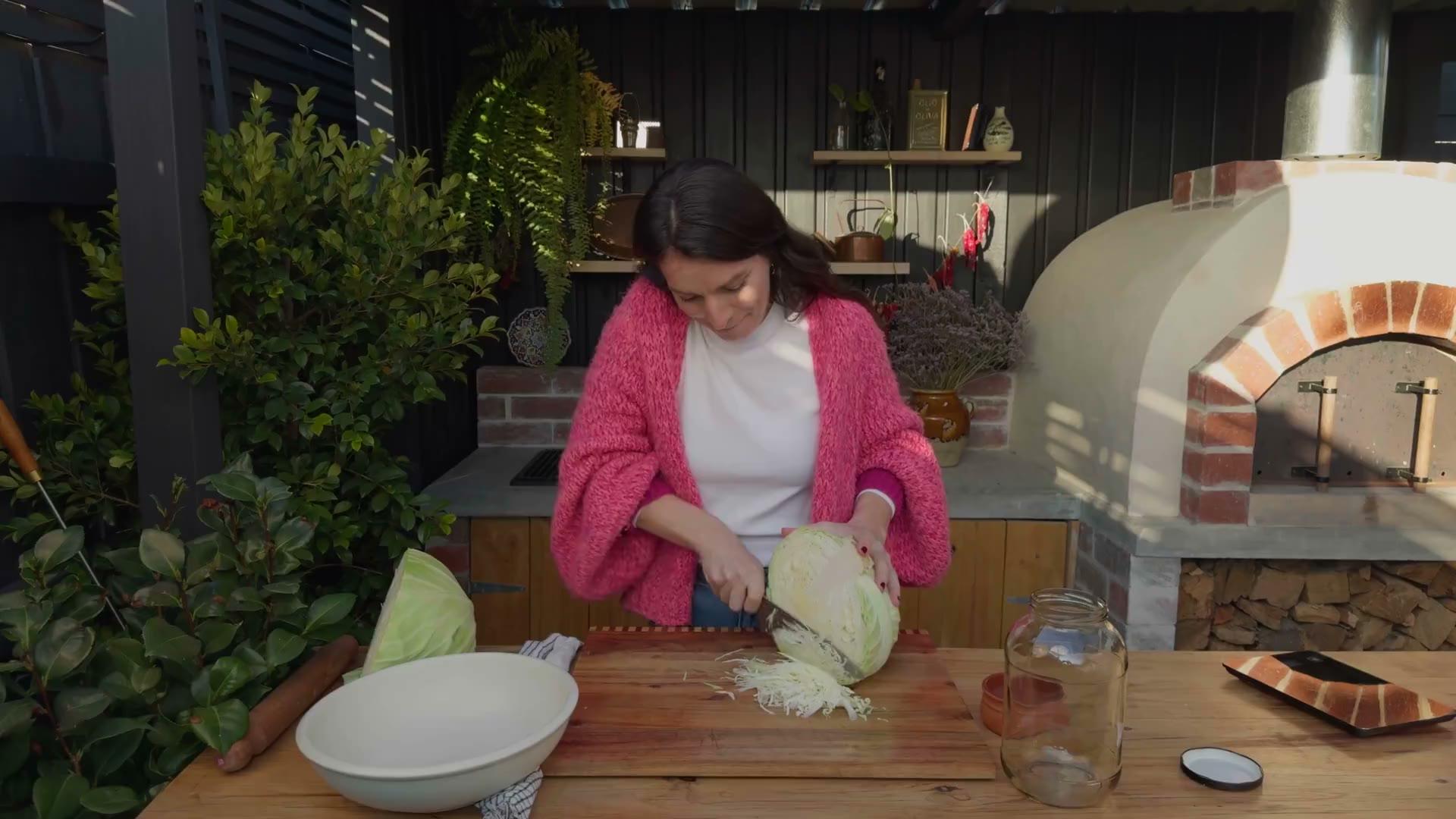Snezana shredding cabbage in her outdoor kitchen